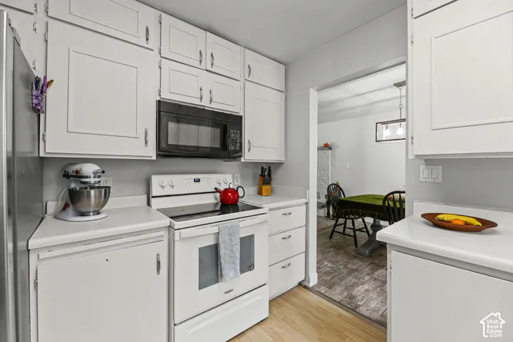 Kitchen featuring white shaker-style cabinetry, solid-surface countertops, and built-in appliances