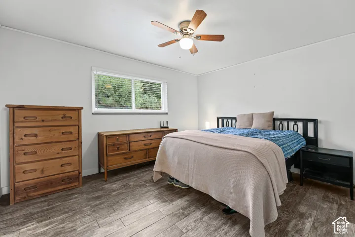 Wood-finish plank flooring, ceiling fan with integrated lighting, and a horizontal sliding window