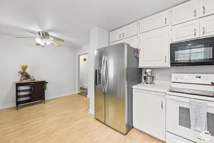 Kitchen featuring white shaker-style cabinetry, wood-finish flooring, stainless steel side-by-side refrigerator, white range, and a ceiling fan with light kit