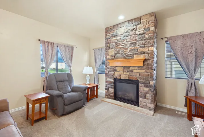 Floor-to-ceiling multi-tonal stacked stone fireplace with a natural wood mantel and gas fireplace.