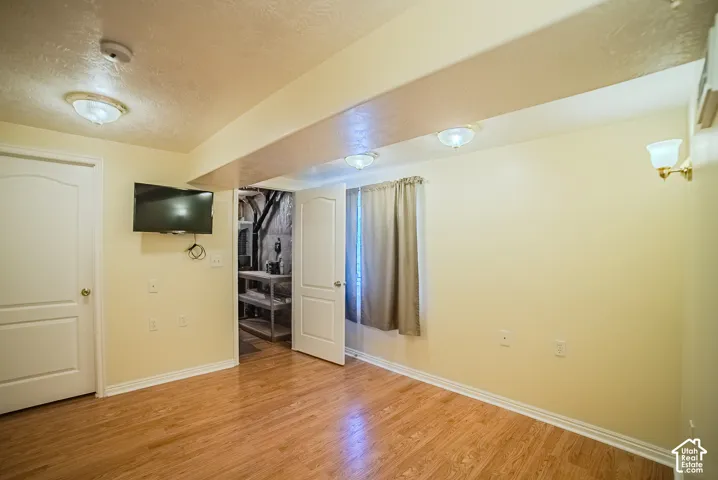 Interior space featuring wood-finish flooring, two-panel arched interior doors, and multiple flush-mount light fixtures