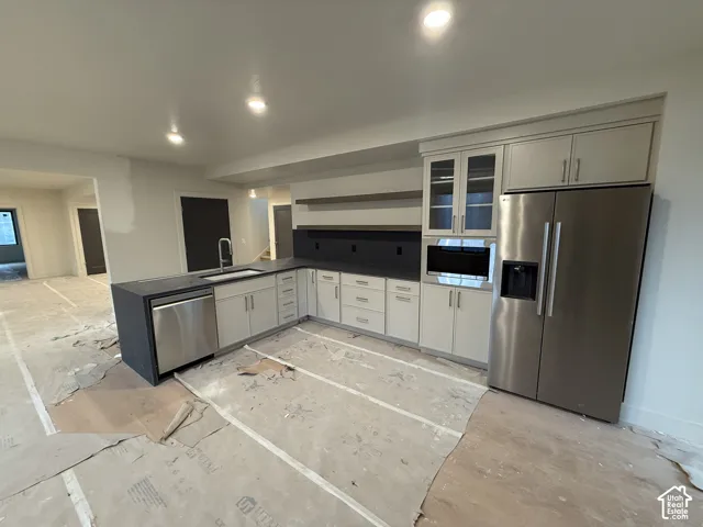 Kitchen featuring flat-panel cabinetry, matte-finish countertops, stainless steel appliances, floating shelving, and recessed lighting