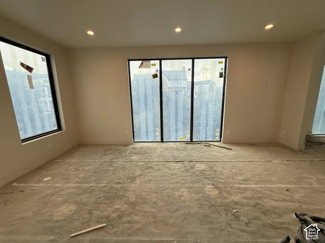 Interior space featuring neutral wall tones, recessed ceiling lighting, and expansive multi-panel windows with black frames