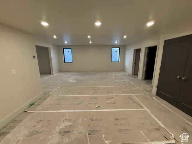 Expansive interior space featuring recessed ceiling lighting, dual rectangular windows, and solid-core charcoal interior doors