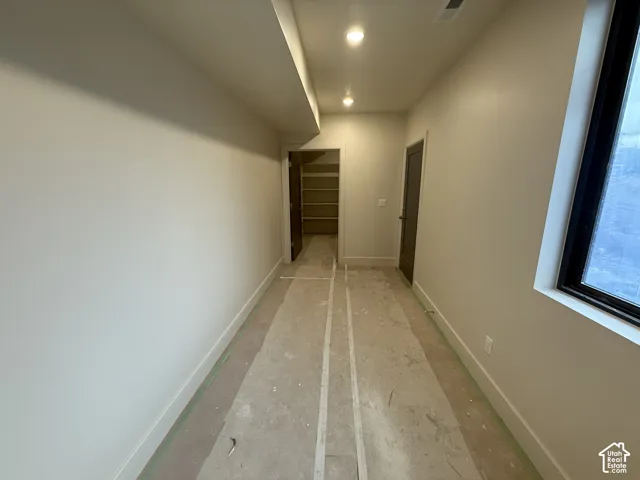 Recessed lighting, large window with dark frame, neutral wall paint, and integrated storage shelving