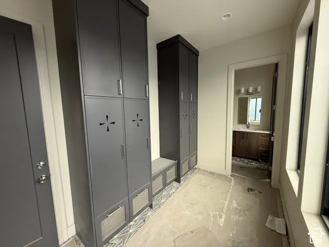 Tall charcoal-toned built-in cabinetry featuring metallic hardware, integrated storage locker detailing, and a low-profile bench seat