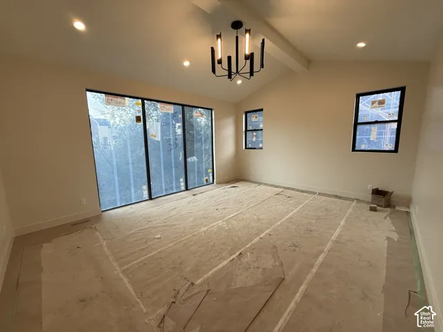 Primary Bedroom featuring Vaulted ceiling with a matte black modern chandelier, floor-to-ceiling multi-panel windows, and recessed lighting