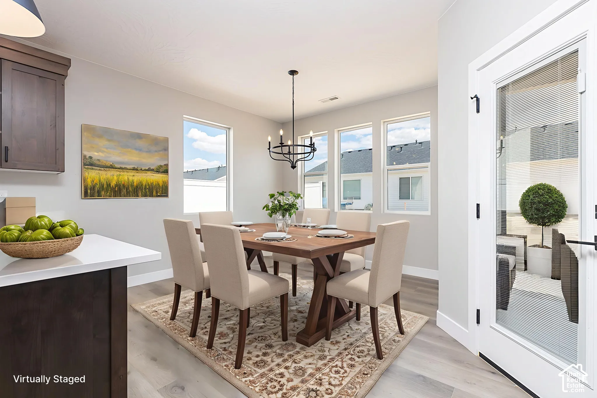 Dining area featuring wood-finish flooring, a tiered metal chandelier, and a glass-paneled exterior door