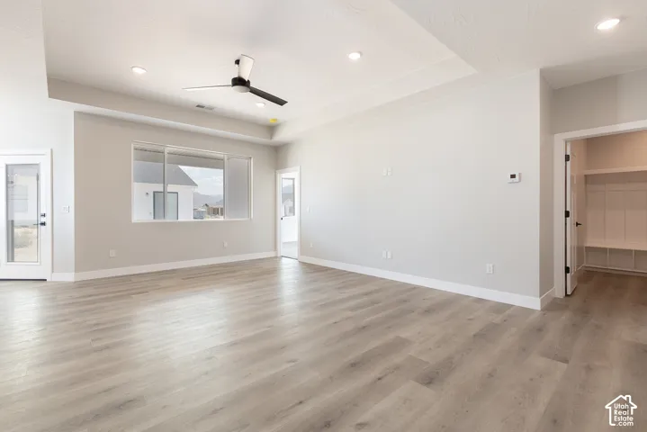 Tray ceiling with recessed lighting, wood-finish flooring, ceiling fan, and built-in mudroom cubbies