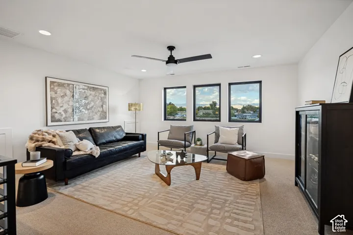 Neutral-toned carpeting, matte black framed windows, recessed lighting, and a modern ceiling fan