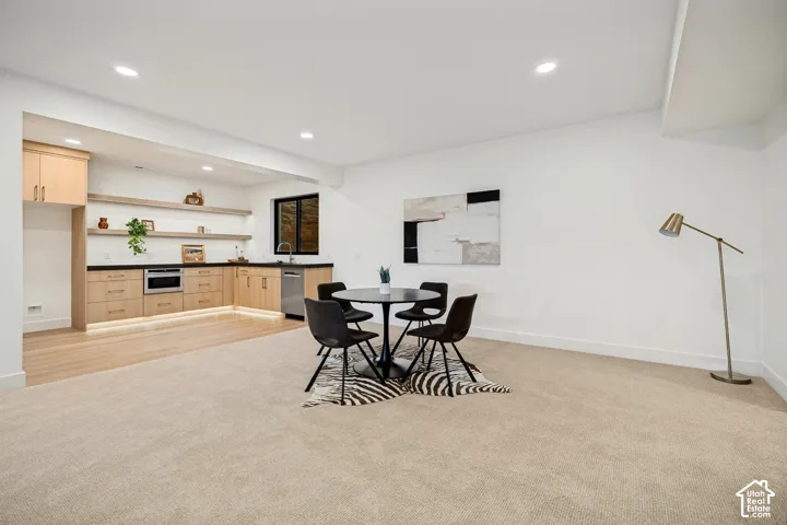 Kitchenette featuring light wood-finish cabinetry, floating shelves, recessed lighting, and stainless-steel appliances