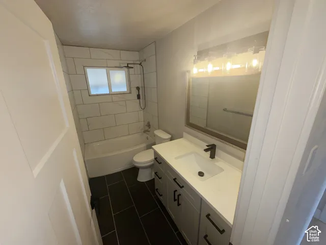 Bathroom featuring a white vanity with a rectangular sink, a black faucet, and a large mirror with integrated lighting