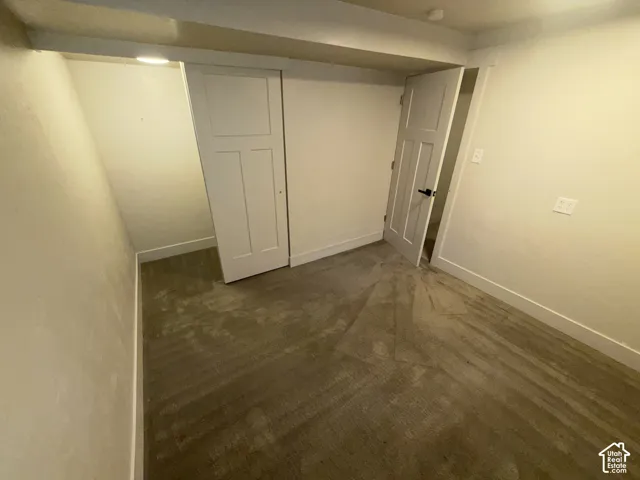 Neutral-toned carpeting, white walls, and white interior doors with black hardware