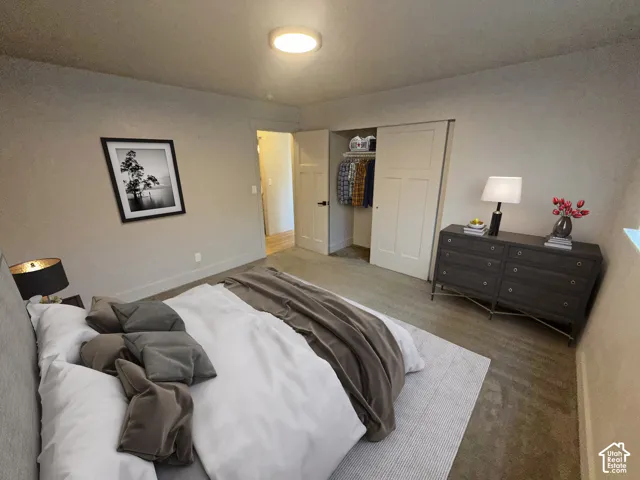 Recessed lighting, wood-finish flooring, and built-in closet with sliding panel doors