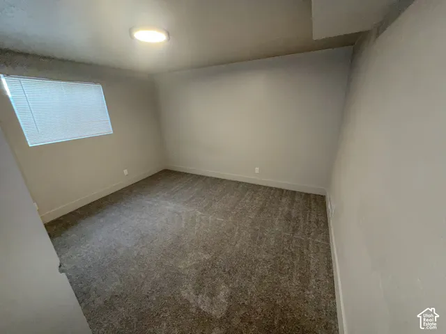 Recessed ceiling lighting, textured carpet flooring, window with blinds, and neutral wall tones