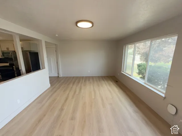 Wood-finish flooring, recessed lighting, expansive windows, half wall separation, and a paneled interior door