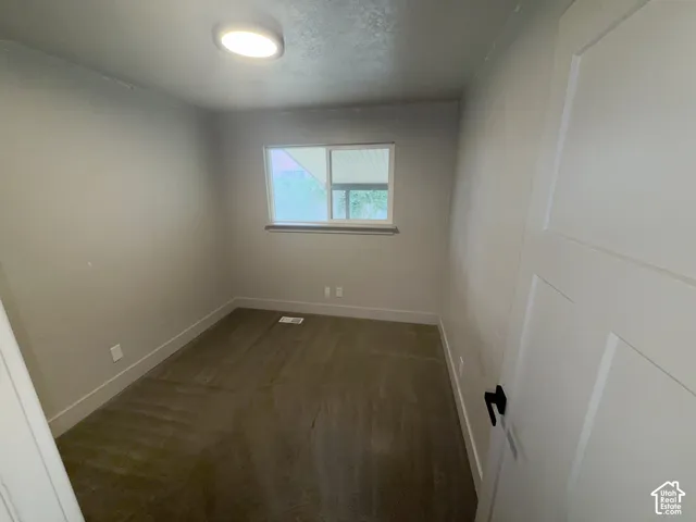 Neutral wall tones, carpeted flooring, white trim, and a window with natural light