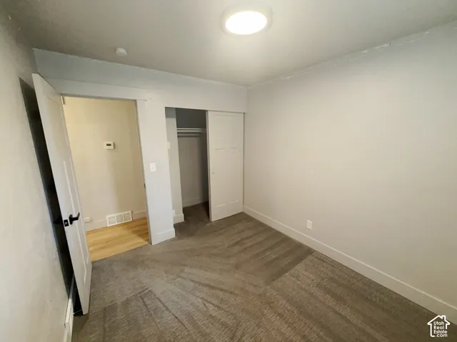 Neutral wall paint, carpet flooring, flat panel closet doors, and recessed ceiling lighting