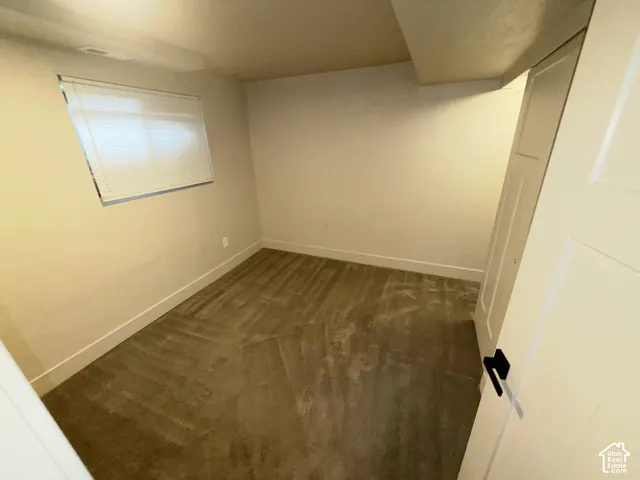 Recessed window with blinds, light-toned walls, and soft carpeting