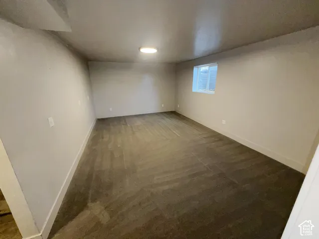 Recessed window with horizontal blinds, overhead flush mount lighting, and grey carpeting