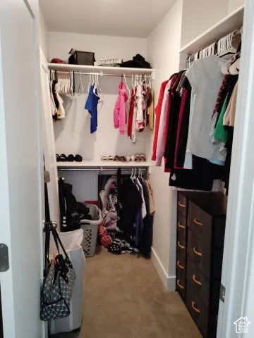 Walk-in closet featuring multi-level hanging rods and integrated upper shelving