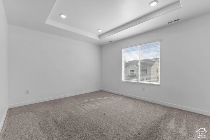 Tray ceiling featuring recessed lighting and wall-to-wall carpeting