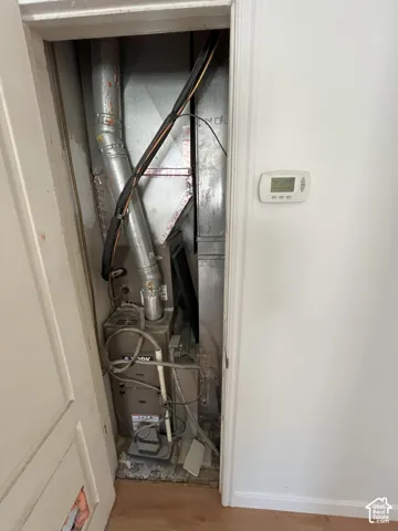 Forced-air furnace system featuring metallic ductwork and a wall-mounted digital thermostat