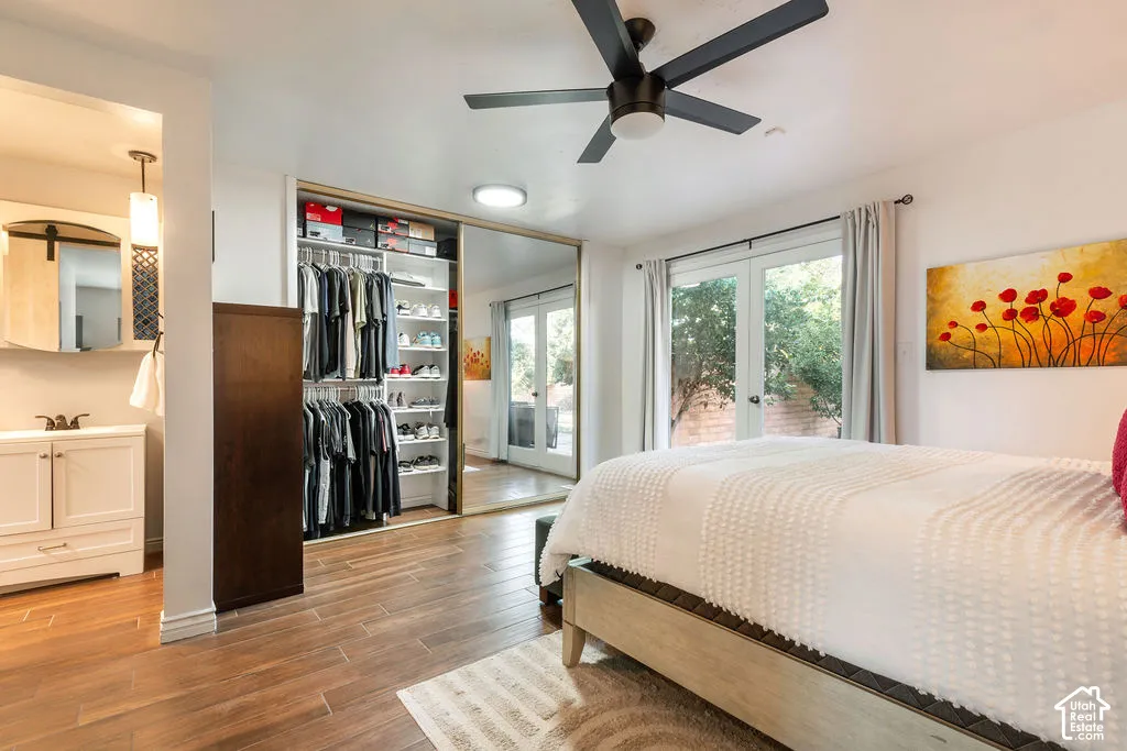 Wood-finish flooring throughout, featuring a built-in closet system with mirrored sliding doors