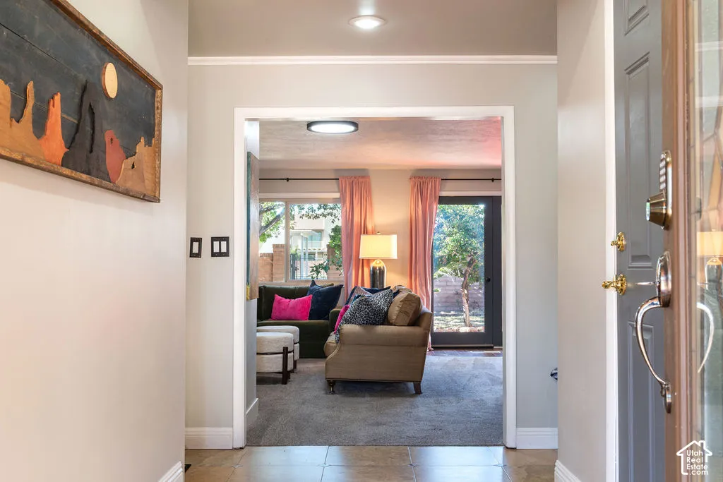 Entryway with tile flooring, a contemporary overhead light fixture, and an open doorway leading to a carpeted living space