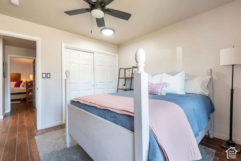 Wood-finish flooring, ceiling fan with integrated lighting, and white bi-fold closet doors