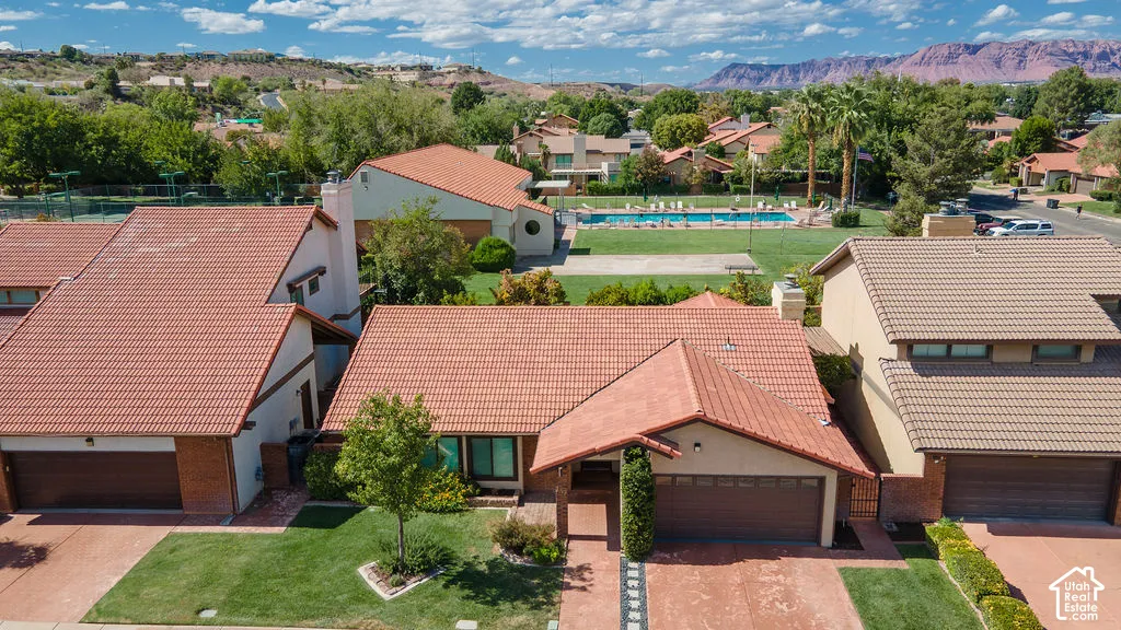 Mediterranean-inspired architecture with terracotta tile roofing and a two-car garage