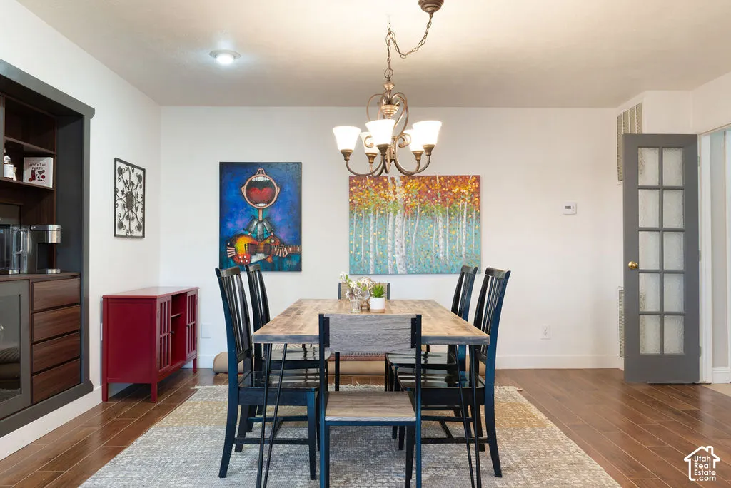 Recessed ceiling lighting, wood-finish flooring, built-in cabinetry, and a multi-light chandelier