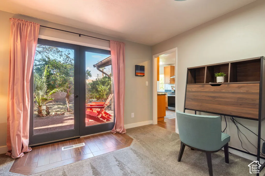 Glass French doors providing direct outdoor access, wood-finish flooring, and light gray wall paint
