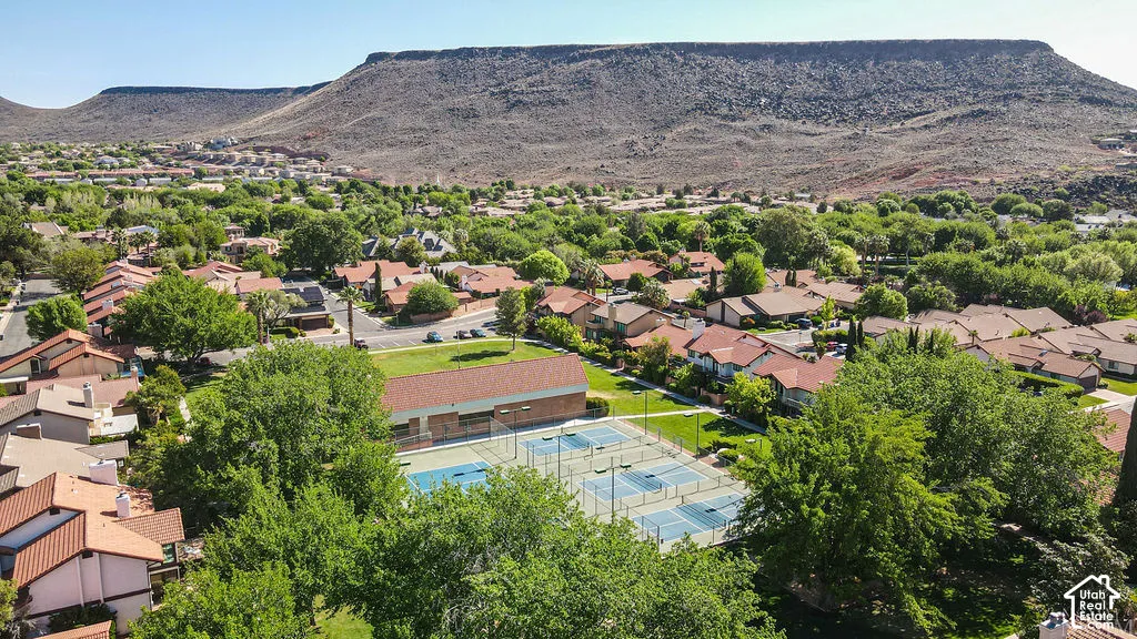 Community with extensive green landscaping, multiple tennis courts, and mountain backdrop
