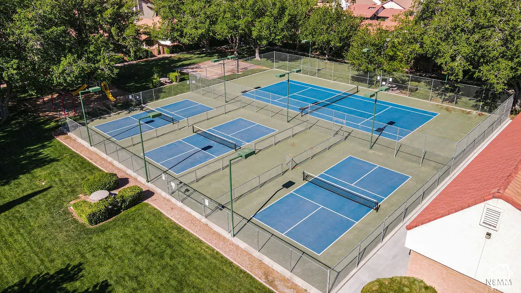Multiple hard courts featuring blue playing surfaces, perimeter fencing, and overhead lighting