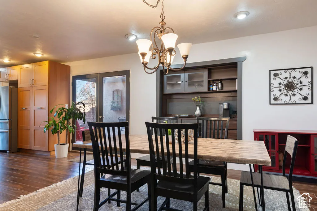 Built-in custom cabinetry, built-in recessed shelving, wood-finish flooring, recessed ceiling lighting, and a decorative chandelier