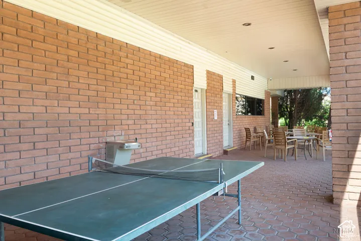 Brick exterior walls with white soffit, covered patio with paver flooring, and recessed lighting