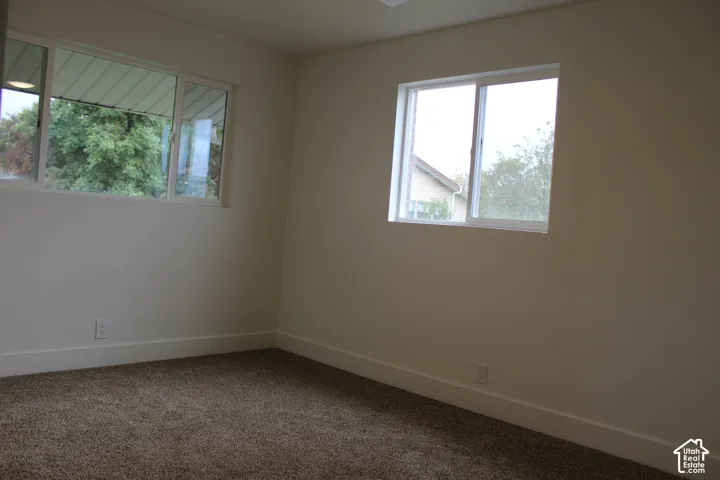 Interior space featuring neutral wall paint, carpeted flooring, and two dual-pane sliding windows