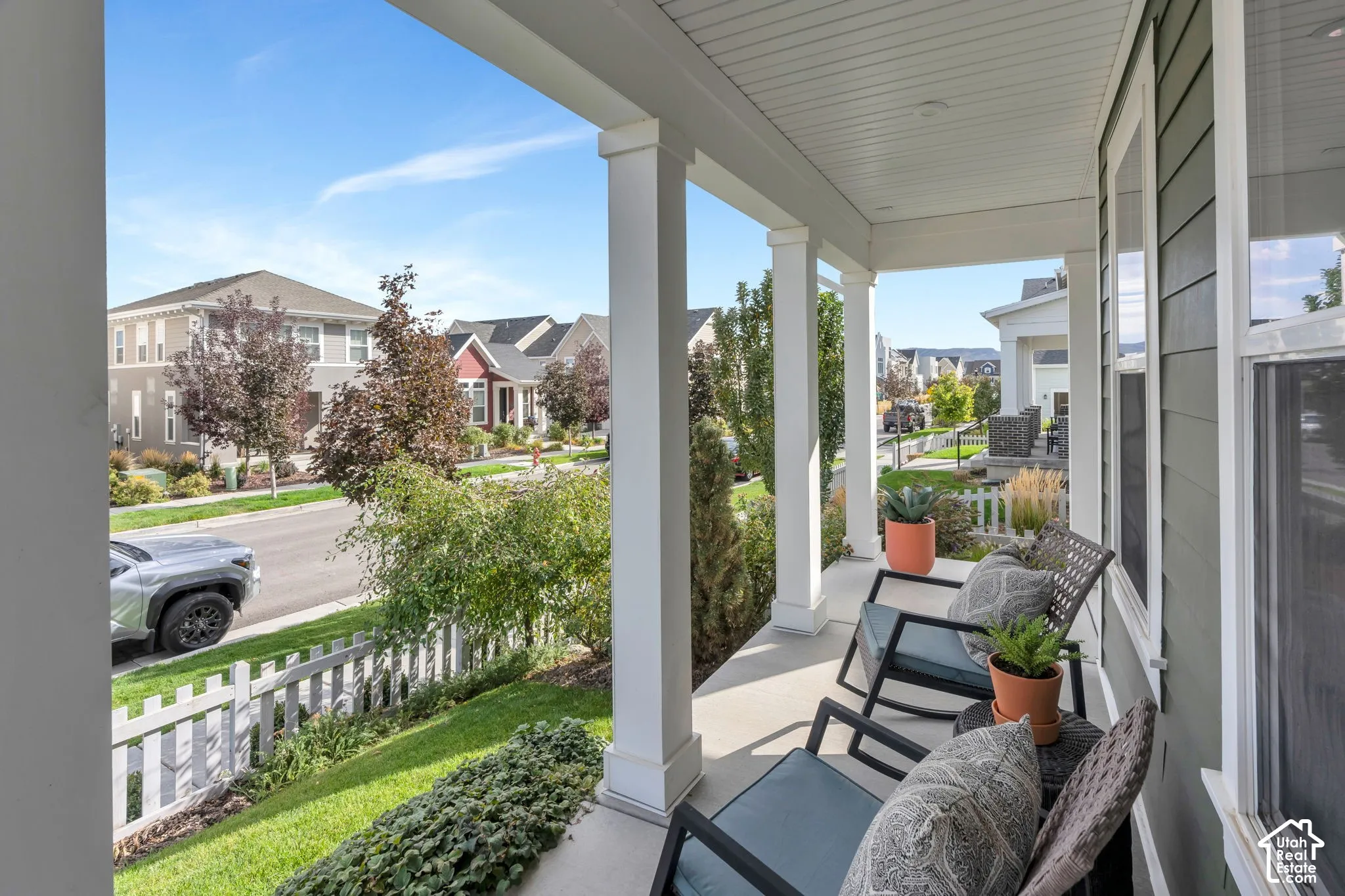 Covered front porch featuring square architectural columns, beadboard ceiling, and concrete flooring
