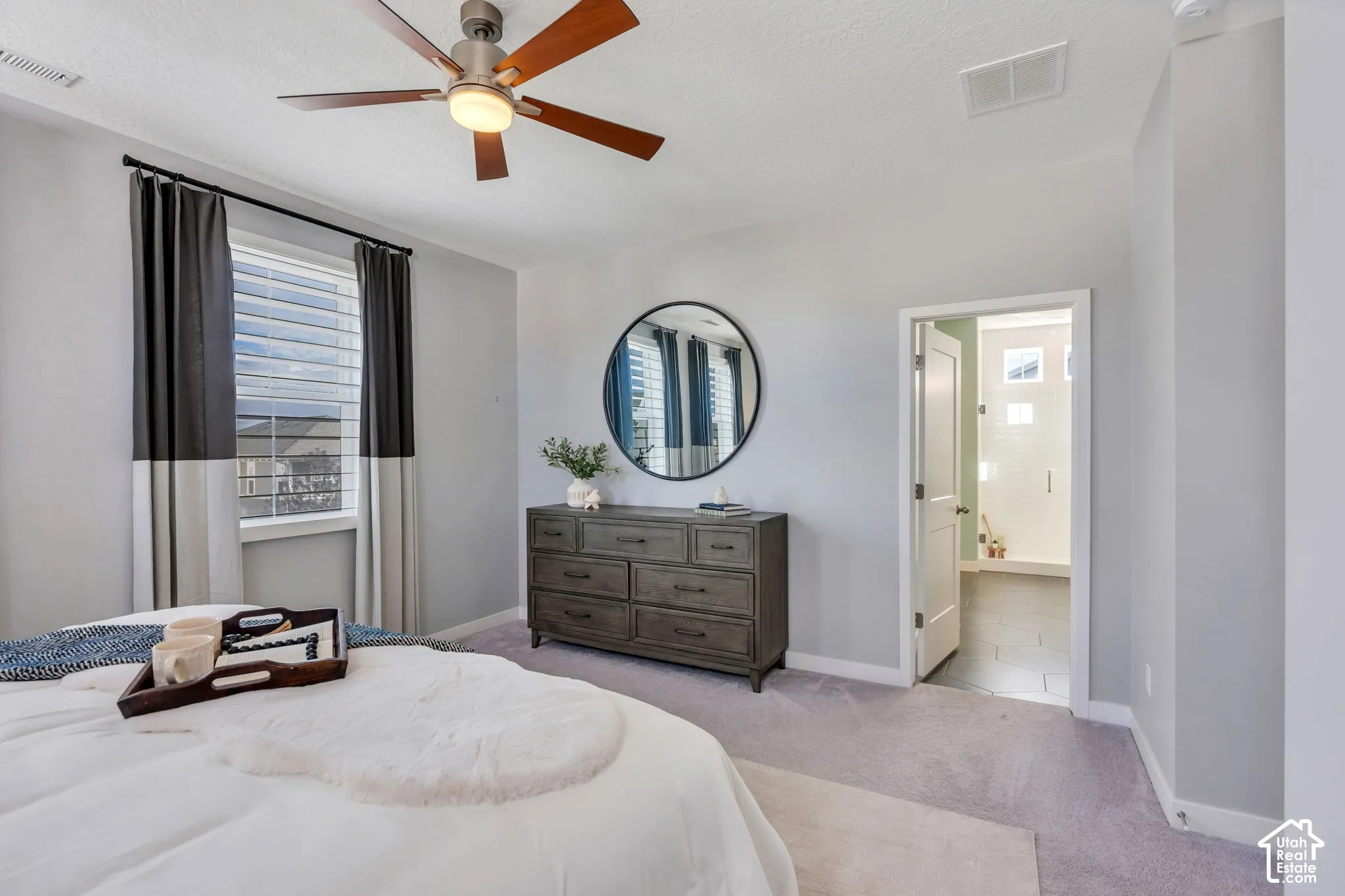 Neutral-toned room featuring a ceiling fan with integrated lighting, carpeted flooring, and a window with horizontal blinds