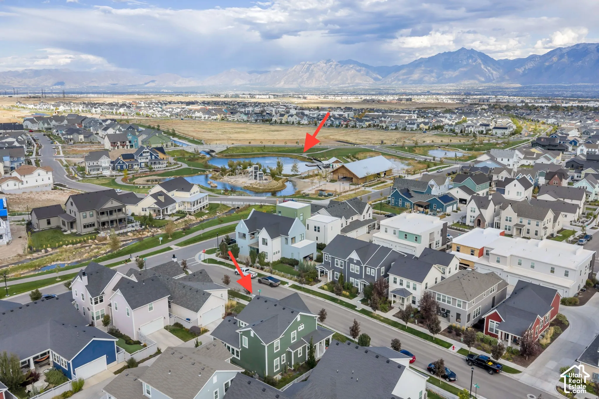 Aerial perspective featuring a two-story residential structure with a shingled roof, set against a backdrop of mountain ranges