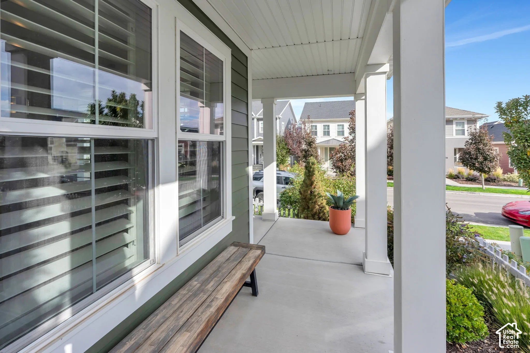 Covered front porch featuring a concrete floor, square support columns, and horizontal lap siding