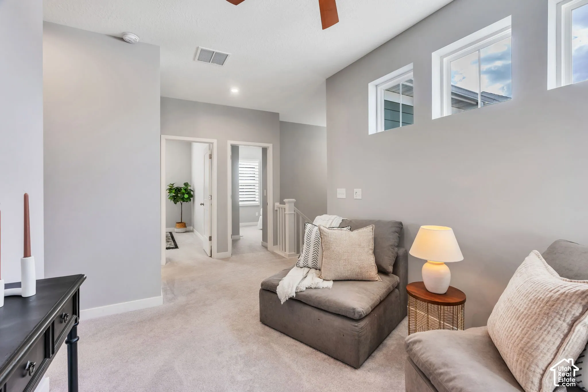 Neutral wall tones, carpeted flooring, multiple rectangular transom windows, and a ceiling-mounted light fixture