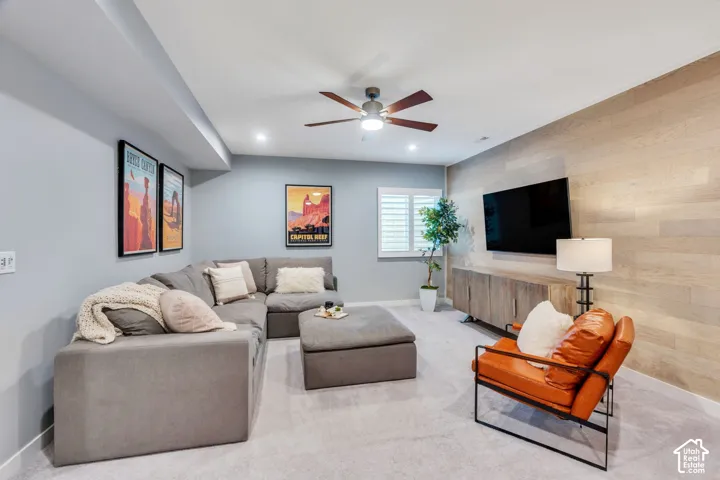 Accent wall featuring horizontal wood-finish planks, recessed ceiling lighting, multi-blade ceiling fan, and window shutters
