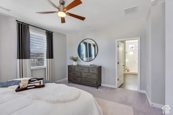 Neutral-toned room featuring a ceiling fan with integrated lighting, carpeted flooring, and a window with horizontal blinds