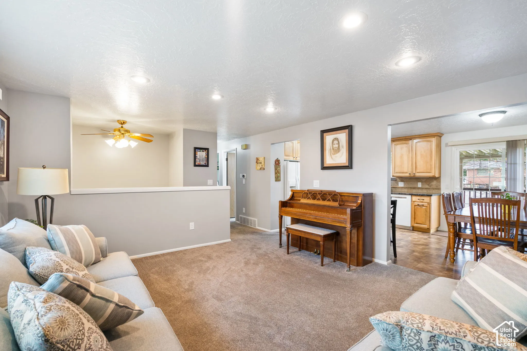 Open-concept living space featuring recessed lighting, a neutral wall color palette, carpeted flooring, and a half-wall partition