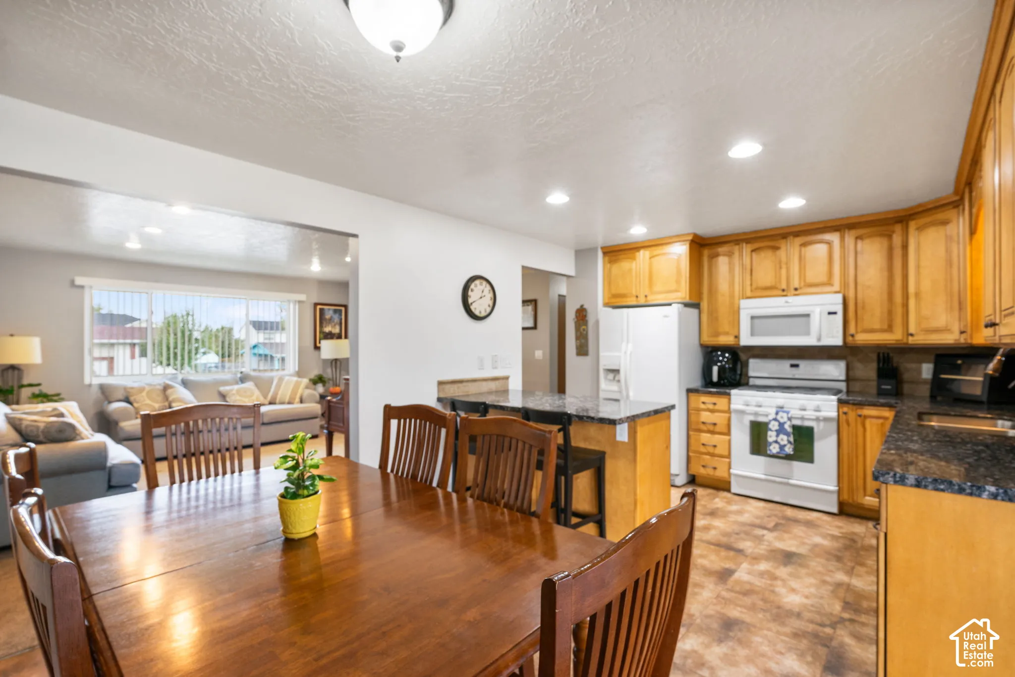 Kitchen area featuring wood cabinetry, stone-finish countertops, built-in microwave, and recessed lighting