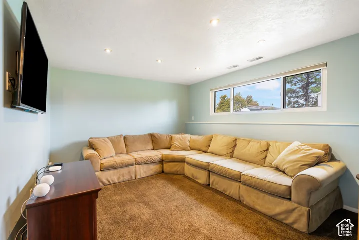 Recessed lighting, wall-to-wall carpeting, and a wide horizontal window with a chair rail