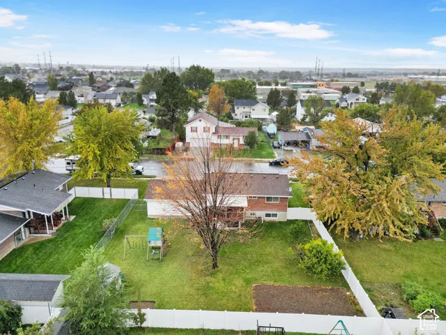 Backyard featuring a white vinyl privacy fence, manicured lawn, and mature trees
