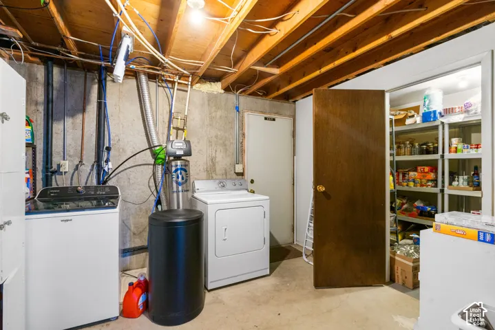 Utility area featuring exposed ceiling joists, concrete foundation walls, a built-in storage pantry, and a water softening system